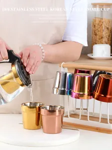 Lifestyle shot of pouring water into colored double-walled 304 stainless steel Korean cups