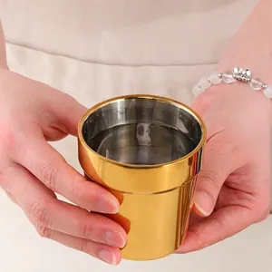 Golden double-walled 304 stainless steel cup for hot beverages in a lifestyle setting