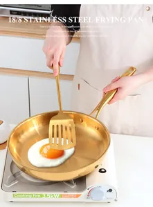 Golden 304 stainless steel frying pan with metal spatula cooking eggs on a stove