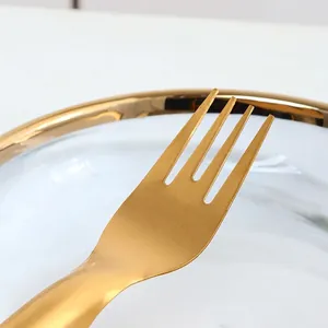 Champagne gold stainless steel fruit fork with brushed finish on marble plate