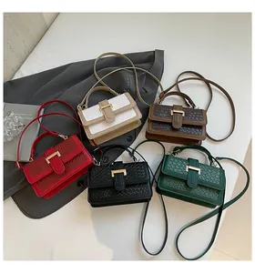 Flat lay of multiple color options for woven texture crossbody bags with gold metal clasps