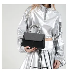 Detailed view of women's handbag with liquid silver metal handle and mixed fabric texture
