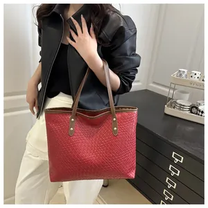 Detail of burgundy woven tote bag showing luxury checkerboard texture and slim straps