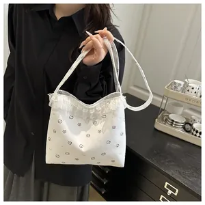 Détail d'un sac cabas blanc avec imprimés de chats et bordures en dentelle raffinée
