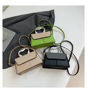 Detail of trendy crossbody bags with silver wave handles and woven texture flap