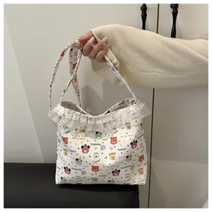 Détails de l'imprimé ours mignon et dentelle blanche sur le sac cabas en toile souple