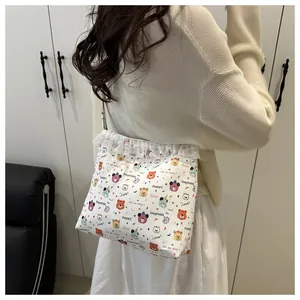 Gros plan d'un sac cabas en toile blanche avec motifs d'ours colorés et bordure dentelle