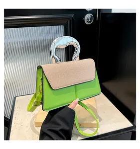 Detail of green leather handbag with silver metallic handle and woven texture flap