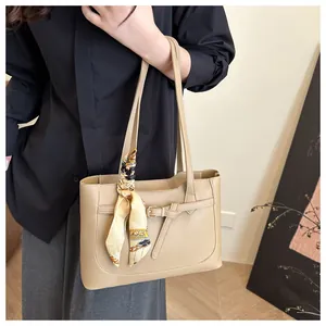 Détail du sac fourre-tout beige en PU avec foulard en soie décoratif et sangle à boucle chic