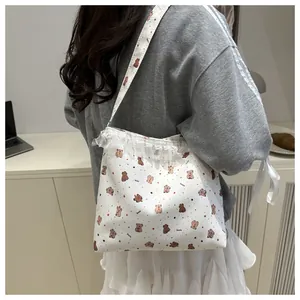 Détail du sac cabas en toile blanche avec motif ours et bordure en dentelle fine