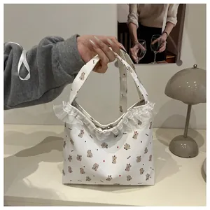 Détail de la bordure en dentelle blanche et du motif koala sur le sac en toile