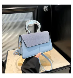 Detail of light blue leather handbag with silver metallic handle and striped flap design