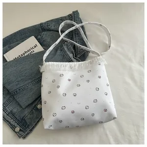 Détail de la dentelle et du motif d'ours sur le sac cabas blanc en toile de coton