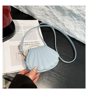 Détail du sac coquillage bleu clair avec poignée en perles et texture matelassée