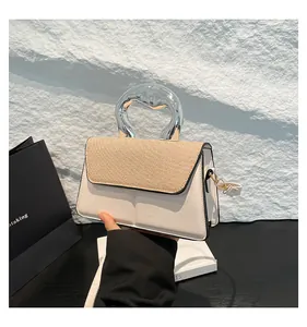 Detail of contrasting panel shoulder bag with unique silver twisted handle and straw flap