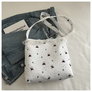 Gros plan détaillé du sac en toile blanche avec motif d'ours et bordure en dentelle