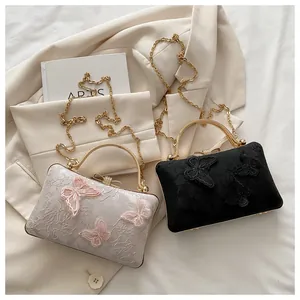 Detail of 3D butterfly embroidery and gold metal handles on small square handbags