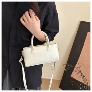 Dettaglio borsa vintage in pelle bianco crema con scritta FASHION in rilievo e tracolla