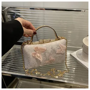 Detail of white lace handbag with 3D pink butterfly appliques and rhinestone handle
