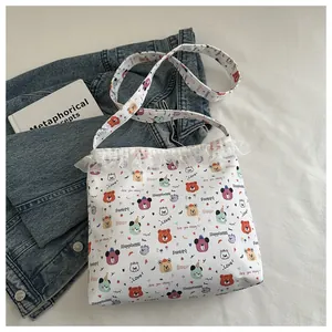Détail de la dentelle et du motif d'ours mignon sur le sac fourre-tout blanc