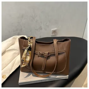 Gros plan d'un sac cabas marron avec poignée en foulard de soie et coutures contrastées