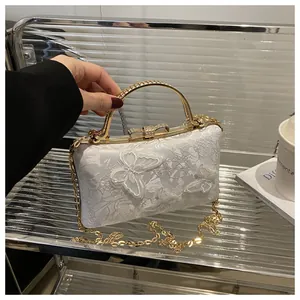Detailed macro view of white lace butterfly embroidery on elegant lady handbag with pearls