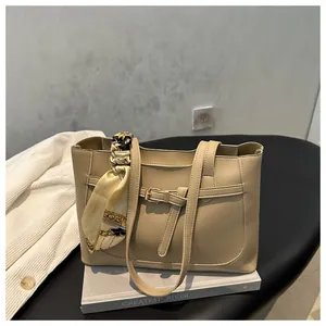 Détail du cabas beige avec foulard en soie vintage sur la poignée et sangle à boucle