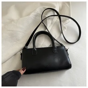 Dettaglio di una borsa a tracolla in pelle nera con logo FASHION goffrato e trama