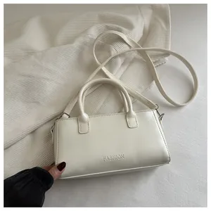 Dettaglio della borsa in pelle PU crema con testo a rilievo e tracolla regolabile