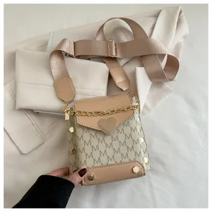 Detail of trendy mini crossbody bag with letter print, heart clasp, and wide fabric strap