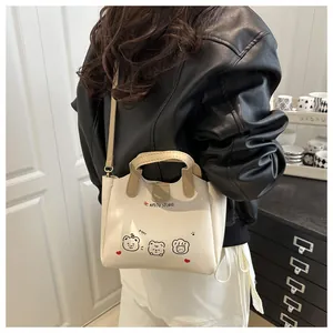 Détail d'un mini sac blanc à bandoulière avec motifs d'ours et poignées contrastées