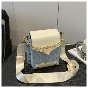 Detail of color-block mini square bag with M-letter prints and gold heart chain