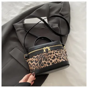 Détails du sac boîte léopard avec ferrures dorées sur une veste de costume grise