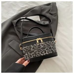 Détail du sac boîte léopard montrant les doubles fermetures dorées et la poignée noire