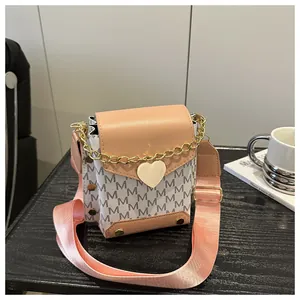 Detail of color-block phone bag with heart lock, monogram print and wide strap
