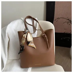 Détail d'un sac cabas marron avec un foulard en soie décoratif et lettrage Fashion & Bags