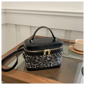 Détail du sac à main boîte avec imprimé léopard et fermeture éclair dorée élégante