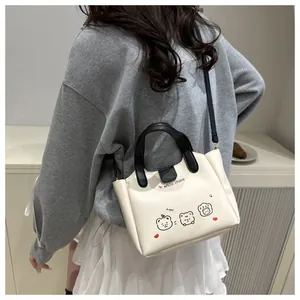 Vue arrière du modèle portant un sac fourre-tout crème avec imprimé ours et anses noires