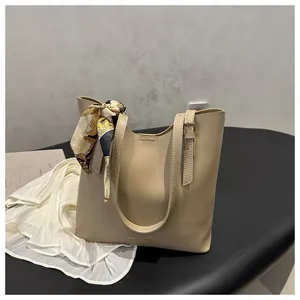 Détail du sac fourre-tout beige avec foulard en soie et boucles métalliques