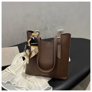 Vue détaillée du sac cabas en cuir marron foncé avec surpiqûres et foulard en soie