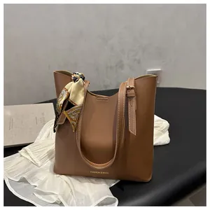 Gros plan d'un sac cabas en similicuir caramel avec foulard en soie et boucle réglable