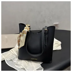 Détail du cabas noir avec surpiqûres blanches contrastées, foulard en soie et dorures