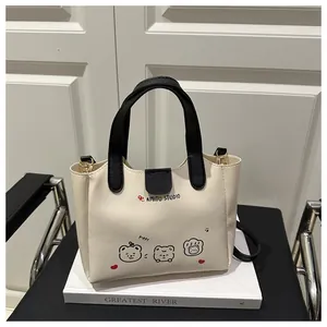Détail du sac cabas crème avec logo AIMITU STUDIO et graphismes de dessins animés