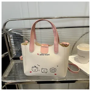 Détail d'un sac cabas blanc et rose avec imprimé chiot cartoon sur étagère métal