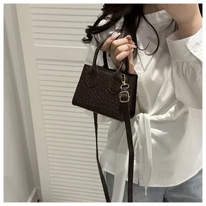 Detail of dark brown woven mini bag with adjustable strap worn by a model in casual style