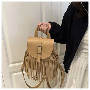 Detailed view of khaki leather tassel bucket bag with vintage buckle and fringe details