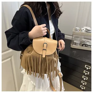 Brown tassel bucket bag styled as a shoulder bag on a model in a minimalist home setting