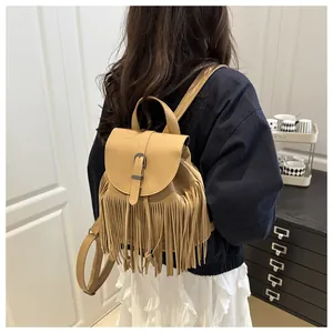 Detail view of bohemian camel faux leather backpack with long fringe and vintage buckle