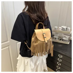 Detail of camel fringe backpack featuring long tassels and metallic buckle closure