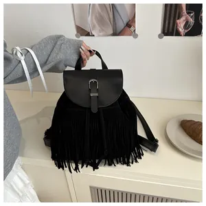 Close-up of black fringe backpack with silver metal buckle and soft leather texture